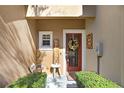 Inviting front door with a decorative wreath and 'Welcome' sign, complemented by vibrant green bushes at 310 Summer Clouds Pl, Brandon, FL 33511