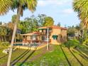 This home features a covered patio, in-ground pool and beautifully maintained lawn surrounded by palm trees at 316 Shore E Dr, Oldsmar, FL 34677