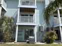Multi-story condo building featuring private balconies, ground floor patio, and lush tropical landscaping at 657 Garland Cir, Indian Rocks Beach, FL 33785