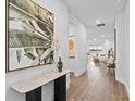 Bright hallway features contemporary art and a view into the open-concept living space at 11341 Hardwood Hammock Ln, Riverview, FL 33569