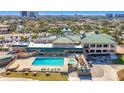 An aerial shot showing a community clubhouse, swimming pool, hot tub, seating, and manicured lawn at 13600 Egret Blvd # 204K, Clearwater, FL 33762