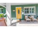 Inviting front porch with seating area and bright yellow door at 263 42Nd Ne Ave, St Petersburg, FL 33703