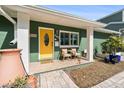 Inviting front porch with seating area and bright yellow door at 263 42Nd Ne Ave, St Petersburg, FL 33703