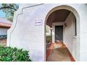 Condo entrance featuring an arched entryway with a brick walkway and attractive landscaping at 3505 Tarpon Woods Blvd # K406, Palm Harbor, FL 34685