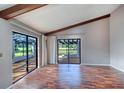 Bright living room featuring hardwood floors, vaulted ceilings with wood beams, and sliding glass doors at 3505 Tarpon Woods Blvd # K406, Palm Harbor, FL 34685