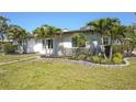 Well-maintained home with decorative shrubs and palm trees in the front yard at 1309 Nokomis S Ave, Venice, FL 34285
