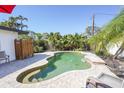Serene backyard pool with lush landscaping, privacy fence, and brick-paved surround at 1309 Nokomis S Ave, Venice, FL 34285