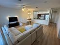 Open-concept living area features a plush sectional sofa, adjacent kitchen and light wood flooring at 1275 Drew St, Clearwater, FL 33755