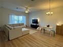 Bright living room features a large sectional sofa, fan, and modern chandelier lighting at 1275 Drew St, Clearwater, FL 33755