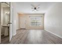 Bright living room with wood floors, ceiling fan, and natural light from the window at 1308 Costa Mesa Dr, Wesley Chapel, FL 33543