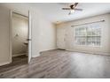 Open-concept living room with wood-look floors, ceiling fan, and plenty of natural light at 1308 Costa Mesa Dr, Wesley Chapel, FL 33543