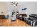 Open living room with vaulted ceilings, stylish parquet floors, and modern ceiling fan at 13215 Parkhurst Ct, Riverview, FL 33569
