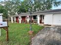 Beautiful home with colorful hanging flower baskets and a well maintained yard at 3108 Ash Ct, Dunedin, FL 34698