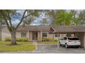 Inviting exterior of a cozy home with a carport and mature landscaping, including an American flag at 20 Sylvia Pl, Oldsmar, FL 34677