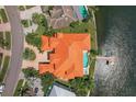 Aerial view of a luxurious waterfront home with a private pool, dock, and lush landscaping at 1097 Eden Isle Ne Dr, St Petersburg, FL 33704