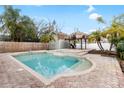 Backyard oasis featuring a refreshing pool, spa and tiki hut perfect for outdoor entertaining and relaxation at 210 Lee St, Oldsmar, FL 34677