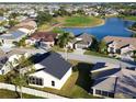 An aerial view of a neighborhood featuring beautiful homes surrounding a golf course and lake on a sunny day at 24156 Buckingham Way, Punta Gorda, FL 33980