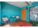 Inviting front porch featuring vibrant colors and a cozy seating area with outdoor furniture on brick pavers at 717 Carolina Ave, Tarpon Springs, FL 34689