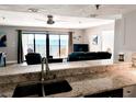 Open-concept kitchen offering granite counters and a view of the living area and ocean at 16330 Gulf Blvd # 306, Redington Beach, FL 33708