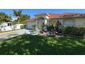 Beautiful single-Gathering home with lush green lawn, mature landscaping, and attached two car garage at 6190 107Th N Ave, Pinellas Park, FL 33782