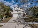 Two-story home with two-car garage, stone accents, and mature landscaping at 6324 Magnolia Trails Ln, Gibsonton, FL 33534