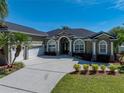 A beautiful home featuring well-kept landscaping, a spacious driveway, and an inviting front entrance at 1111 Carriage Park Dr, Valrico, FL 33594