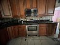 Kitchen features wooden cabinets, dark countertops, and stainless steel appliances at 1530 Davenport Dr, New Port Richey, FL 34655