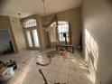 A spacious living room features large windows, a chandelier, and tile flooring at 1530 Davenport Dr, New Port Richey, FL 34655