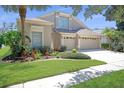 Charming home showcasing verdant lawn, colorful plants, and a three-car garage at 15555 Martinmeadow Dr, Lithia, FL 33547