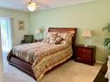 Cozy bedroom with neutral walls, a ceiling fan, and large windows for natural light at 1655 S Highland Ave # J193, Clearwater, FL 33756