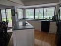 Bright kitchen features an island with cooktop, a large picture window, and stainless steel appliances at 1735 Tall Pine Cir, Safety Harbor, FL 34695
