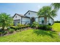 Beautiful home with manicured lawn, mature palm trees and lush landscaping creating curb appeal at 4748 Ballast Crest Cv, Land O Lakes, FL 34638