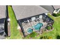 Aerial view of screened-in kidney-shaped pool and spa, surrounded by a paver patio and landscaping at 4748 Ballast Crest Cv, Land O Lakes, FL 34638