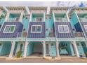 Charming coastal-style townhomes featuring colorful exteriors, balconies, and garage parking at 11721 1St E St, Treasure Island, FL 33706