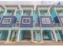 Charming coastal townhomes featuring a blue exterior with private balconies and covered parking at 11721 1St E St, Treasure Island, FL 33706