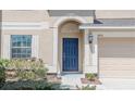 Inviting front entryway showcasing a blue front door and manicured landscaping at 18311 Arbor Crest Dr, Hudson, FL 34667