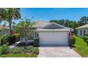 Beautiful single-story home with a two-car garage, neatly trimmed landscaping, and a brick driveway at 15856 Cobble Mill Dr, Wimauma, FL 33598