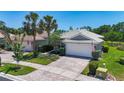 Attractive single-story home featuring a two-car garage, brick driveway, and neatly maintained landscaping at 15856 Cobble Mill Dr, Wimauma, FL 33598