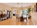 Bright dining room featuring hardwood floors, elegant chandelier, and access to the screened-in pool area at 16103 Muirfield Dr, Odessa, FL 33556