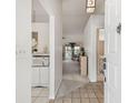 Inviting entryway featuring neutral tile flooring, a modern white storage cabinet, and views into the living area at 4210 Revere Cir, New Port Richey, FL 34653