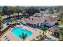 Aerial view of community pool with lounge chairs, clubhouse, and lush landscaping at 4210 Revere Cir, New Port Richey, FL 34653