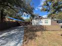 Charming home featuring a cozy front yard with a picket fence and a paved driveway at 8014 N Alaska St, Tampa, FL 33604