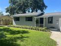 Charming single-story home with beautiful landscaping and dark shutters on the windows at 6923 Dartmouth N Ave, St Petersburg, FL 33710