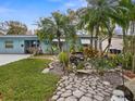 Landscaped front yard with a stone path leading to a beautiful waterfall feature at 8501 47Th N St, Pinellas Park, FL 33781