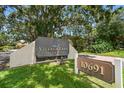 The Village Lake Condominiums community sign is set against a backdrop of mature trees and lush landscaping at 880 S Village Lake N Dr # 106, St Petersburg, FL 33716