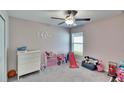 Bright bedroom featuring a ceiling fan, plush carpet, and a cozy play area at 11210 Kelly Green Ave, Wimauma, FL 33598