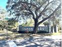 Entrance to the Sharon Oaks neighborhood with mature trees and well-maintained landscaping at 2450 Roberta Ln, Clearwater, FL 33764