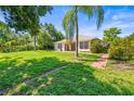 Expansive backyard with mature trees, a well-kept lawn, and a patio area perfect for outdoor relaxation at 4251 Whittner Dr, Land O Lakes, FL 34639