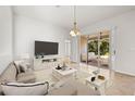 Bright living room with neutral tones and sliding glass doors to a patio sitting area at 4251 Whittner Dr, Land O Lakes, FL 34639