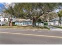 Charming blue brick home featuring a covered front porch with white columns and mature trees at 710 S Davis Blvd, Tampa, FL 33606